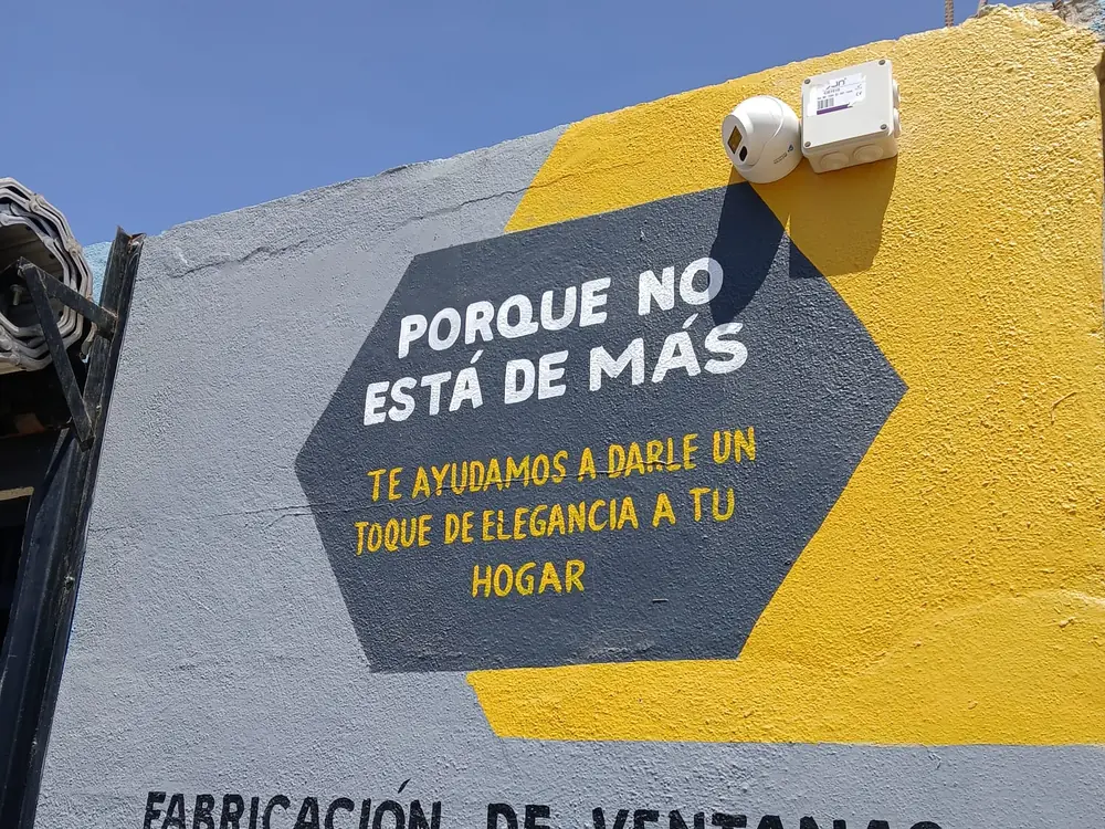 Cámara domo blanca montada en muro junto a su caja de conexiones sellada